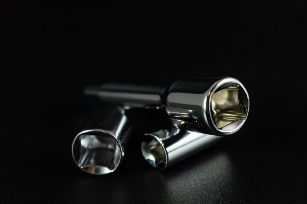 A studio shot of chrome socket wrenches displaying precision and metallic shine against a dark background.